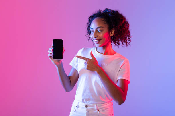 istock Woman indicating phone screen in purple light 2166933534