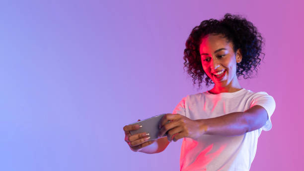 istock Woman playing game on smartphone in neon light 2166933543