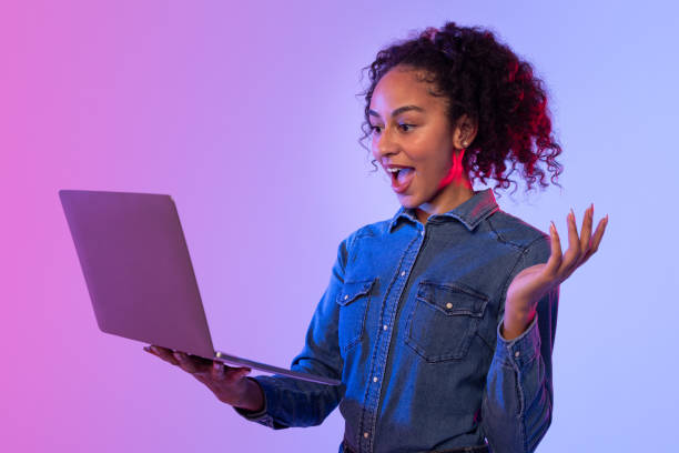 istock Excited woman with arms open using laptop 2166933566