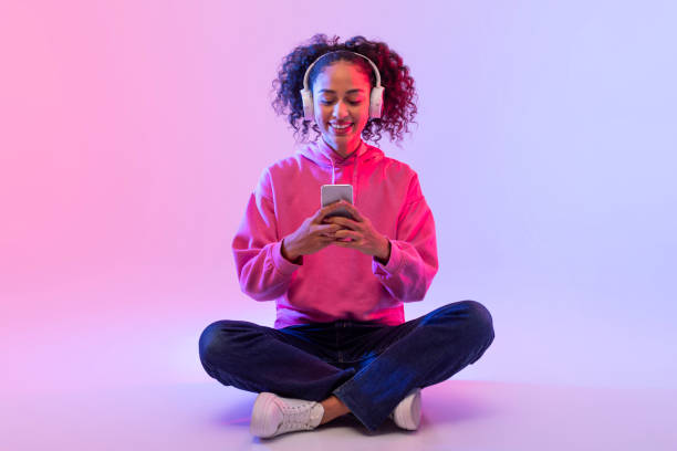 istock Casual woman using phone sitting cross-legged 2166933581