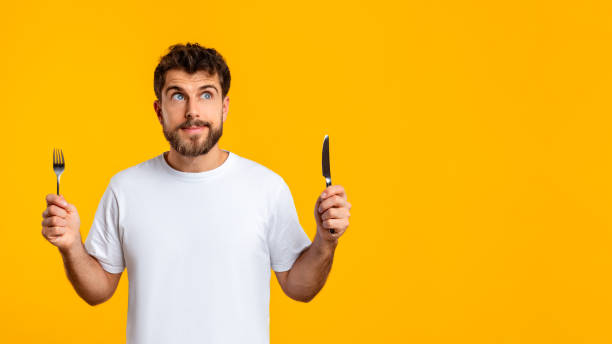 istock Hungry guy holds knife and fork ready savor meal, studio 2166933858