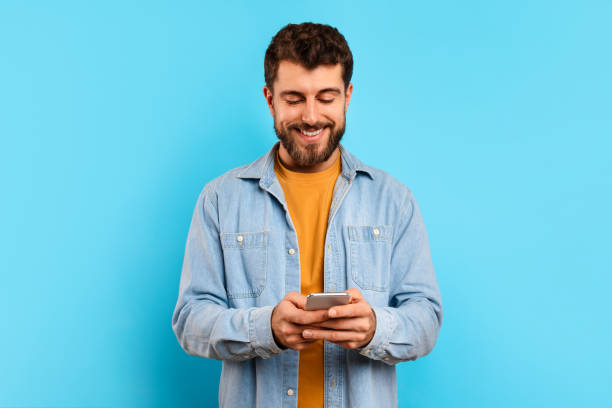 istock Happy young man browsing an app on his smartphone, studio 2166933875
