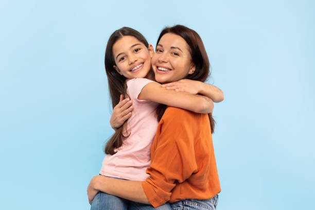 istock Happy Young Mom Hugging Her Little Daughter Over Blue Background 2166934202