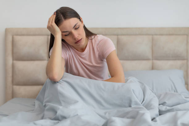 istock Woman sitting in bed with headache or stress 2166934671