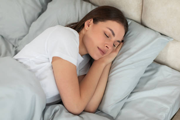 istock Serene woman sleeping peacefully in cozy bed 2166934701