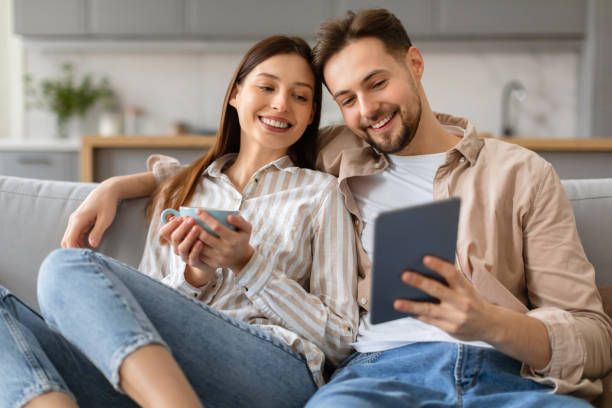 istock Young couple relaxing at home with coffee and tablet 2166934731
