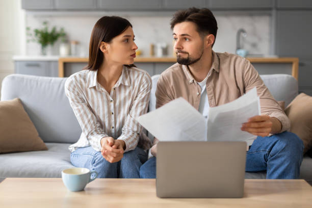 istock Worried couple reviewing documents with laptop 2166934733
