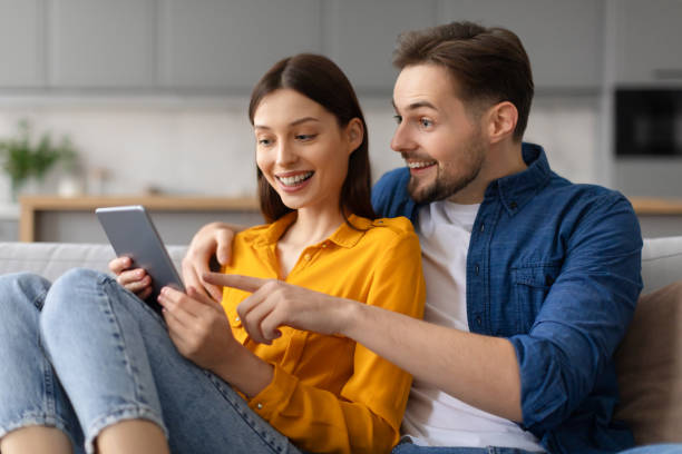 istock Excited caucasian spouses using digital tablet on the couch 2166934753