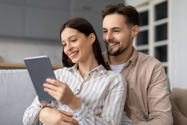 istock Happy european spouses sharing moment with digital tablet 2166934773