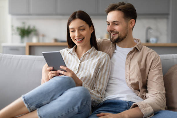 istock Relaxed spouses enjoying tablet time together on sofa 2166934775