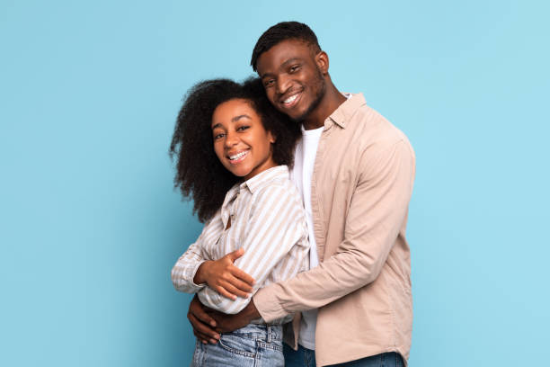 istock Loving black couple embracing with bright smiles on blue 2166934859