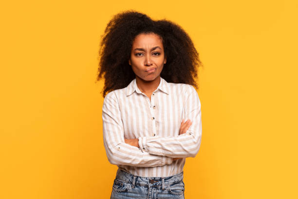 istock Skeptical black lady with arms crossed on yellow background 2166934865