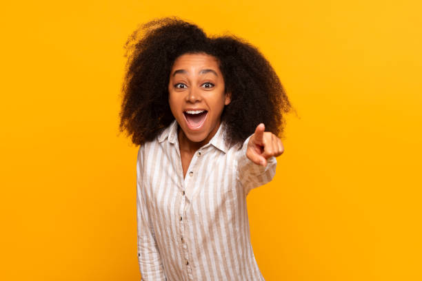 istock Excited woman pointing forward on yellow background 2166934887