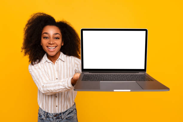 istock Young woman presenting laptop screen on yellow background 2166934908