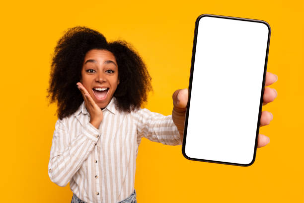 istock Excited woman showing smartphone screen on yellow background 2166934921