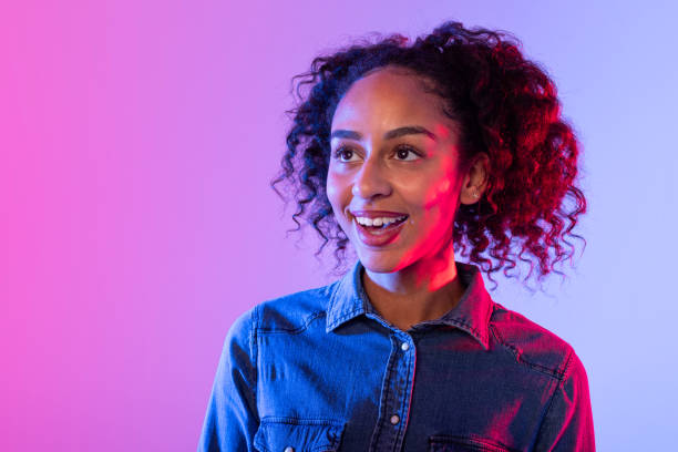 istock Smiling woman in denim jacket with glowing backdrop 2166934979