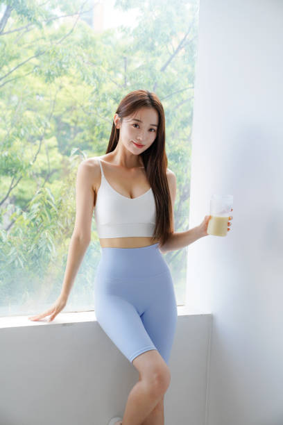 istock Young Asian woman drinking a protein drink 2166939587