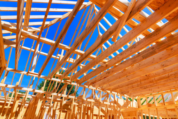 istock An constructs wooden roof beams using trusses, rafters, a joists for framework. 2166939956