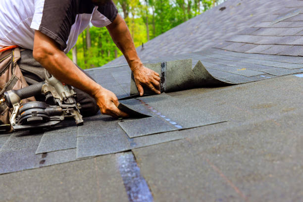 istock Construction worker using pneumatic nail gun to install new bitumen shingles on a roof 2166939992