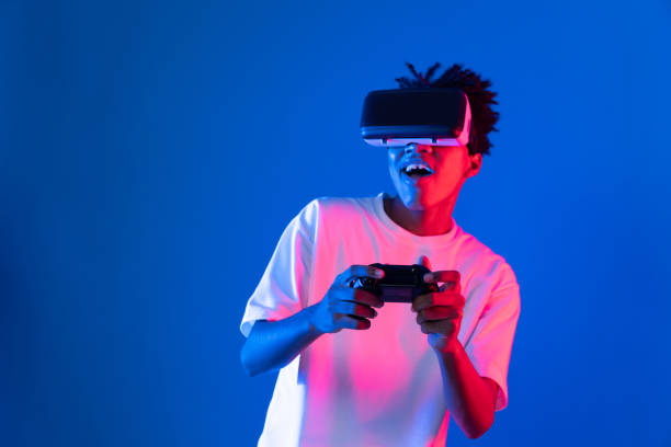 istock American African player wearing VR joystick neon lighting wall. Contrivance. 2166940126