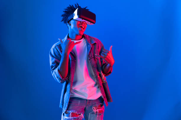 istock Smiling African looking VR dancing hologram on pink blue neon wall. Contrivance. 2166941177
