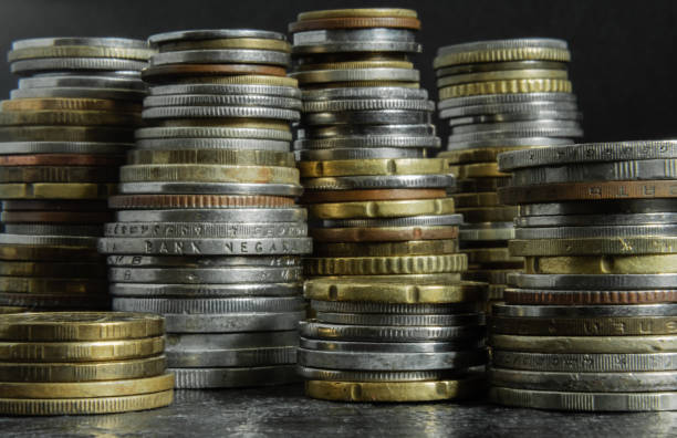 istock Several stacks of coins of different heights on a black background 2166942089