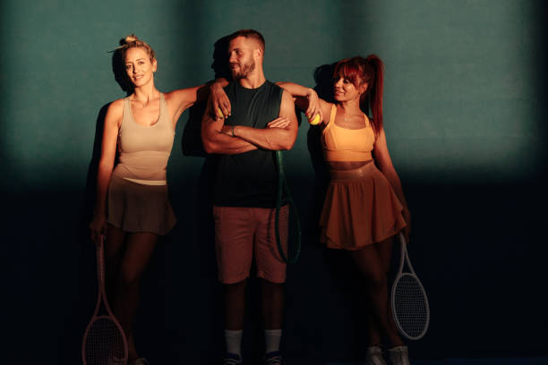 istock Three tennis players posing in front of a blue wall 2166942494