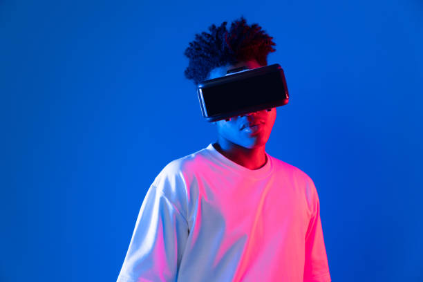 istock Surprised African looking VR holding object hologram neon wall. Contrivance. 2166944047