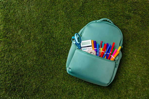 istock Back to School Backpack with Supplies on a Green Grass Background 2166944634