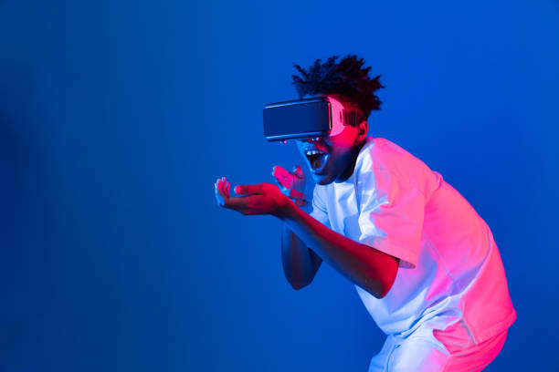istock Young African American player using VR turn hunter game neon wall. Contrivance. 2166944913