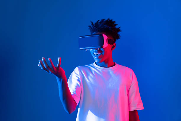 istock Surprised African looking VR holding object hologram neon wall. Contrivance. 2166944955