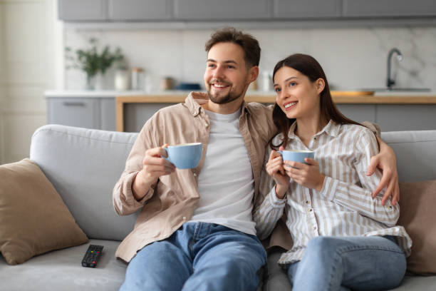 istock Spouses with coffee cups enjoying time on sofa 2166947642