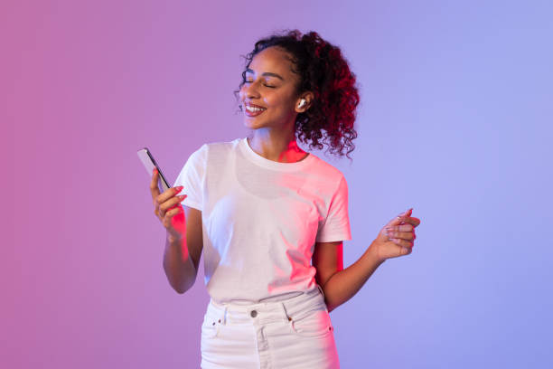 istock Curly-haired woman holding phone and gesturing 2166948573