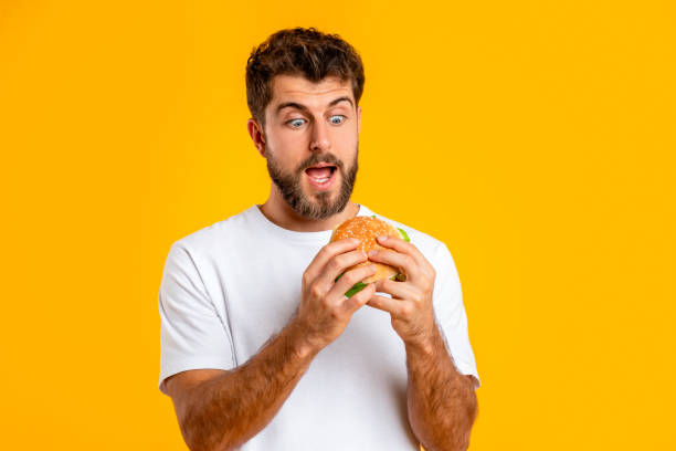 istock Excited Millennial Man Looking At Burger With Open Mouth, Studio 2166948574