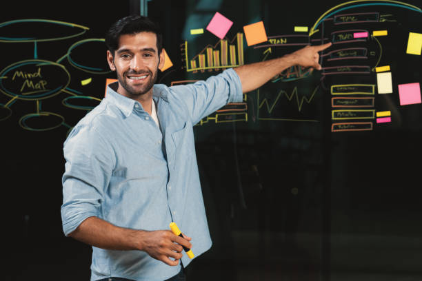 istock Businessman pointing at marketing statistic while looking at camera. Tracery. 2166950544
