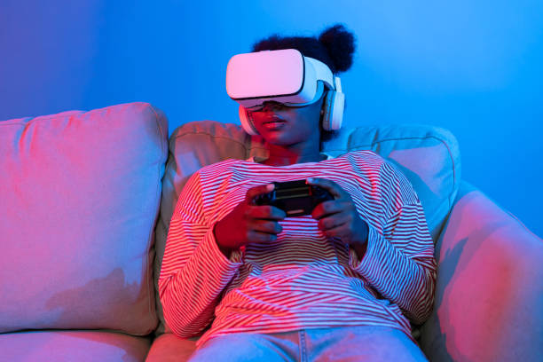 istock Smiling African playing gaming player wearing VR control joystick. Contrivance. 2166962023