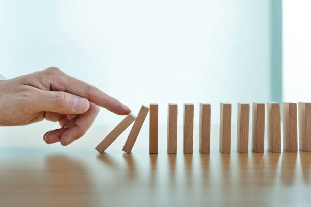 istock Man finger pushing domino pieces 2166963195