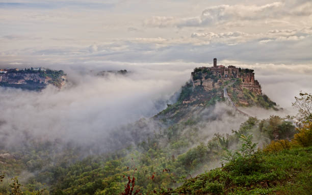 Civita di Bagnoregio, Viterbo, Lazio, Italy: suggestive landscape at dawn of the ancient village shrouded in fog on the steep tuff hill