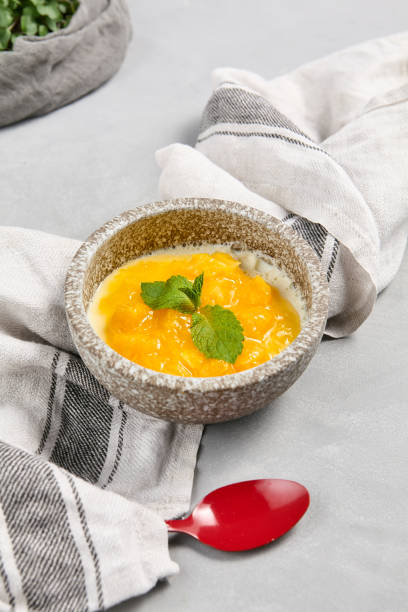 istock Fresh Mango Panna Cotta Dessert in Rustic Bowl with Mint Garnish on Linen Cloth 2166976230