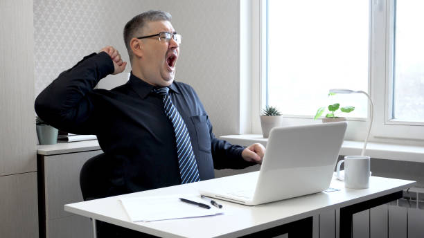 istock Tired Man Stretching and Yawning in Office 2166978137
