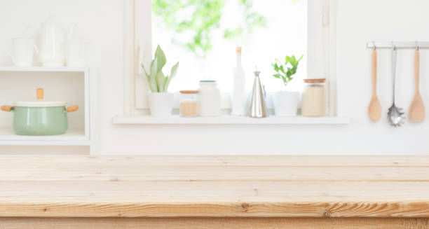 istock Empty wood table top counter and blur kitchen window interior background ready for product montage 2166980157