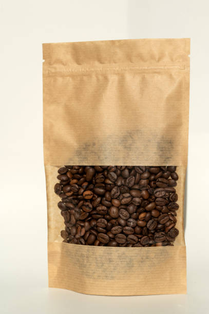 istock A kraft paper bag with coffee beans for viewing with a highlighted shadow lies on a white background 2166981300