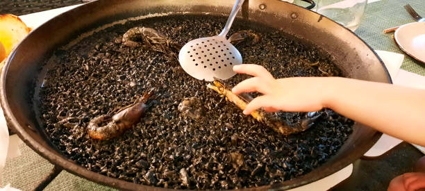 istock Arroz negro ,black rice, prawns on top. 2166987234