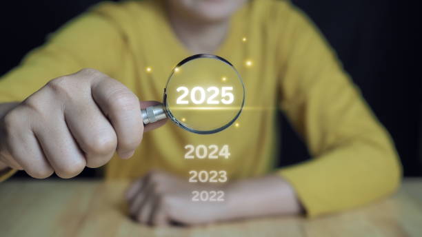 istock Businessman use magnifying glass focus to 2025 text on virtual screen, positive indicators 2025.business strategy planning in new year, start. 2166989332