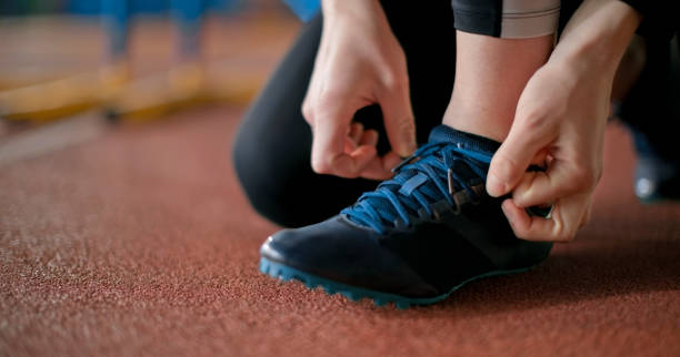 istock Female athlete's hand tying shoelace 2166989433