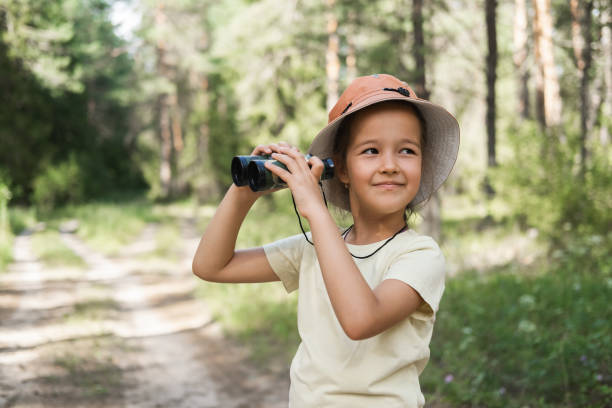 istock Cute little girl exploring nature looking through binoculars. 2166992859