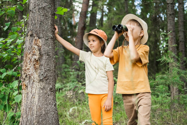 istock Adventure children are using a binocular while they travel the jungle. 2166992878