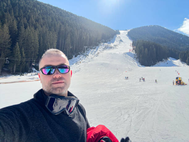 A skier capturing a stunning winter landscape on his smartphone.