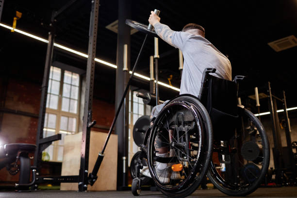 istock Man using Wheelchair Lifting Weighs in Gym 2167003439