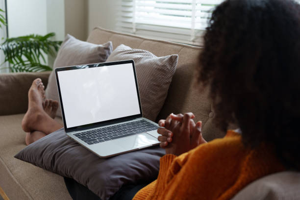 istock Afro American woman relaxing on couch, using laptop with blank screen at home. 2167005905